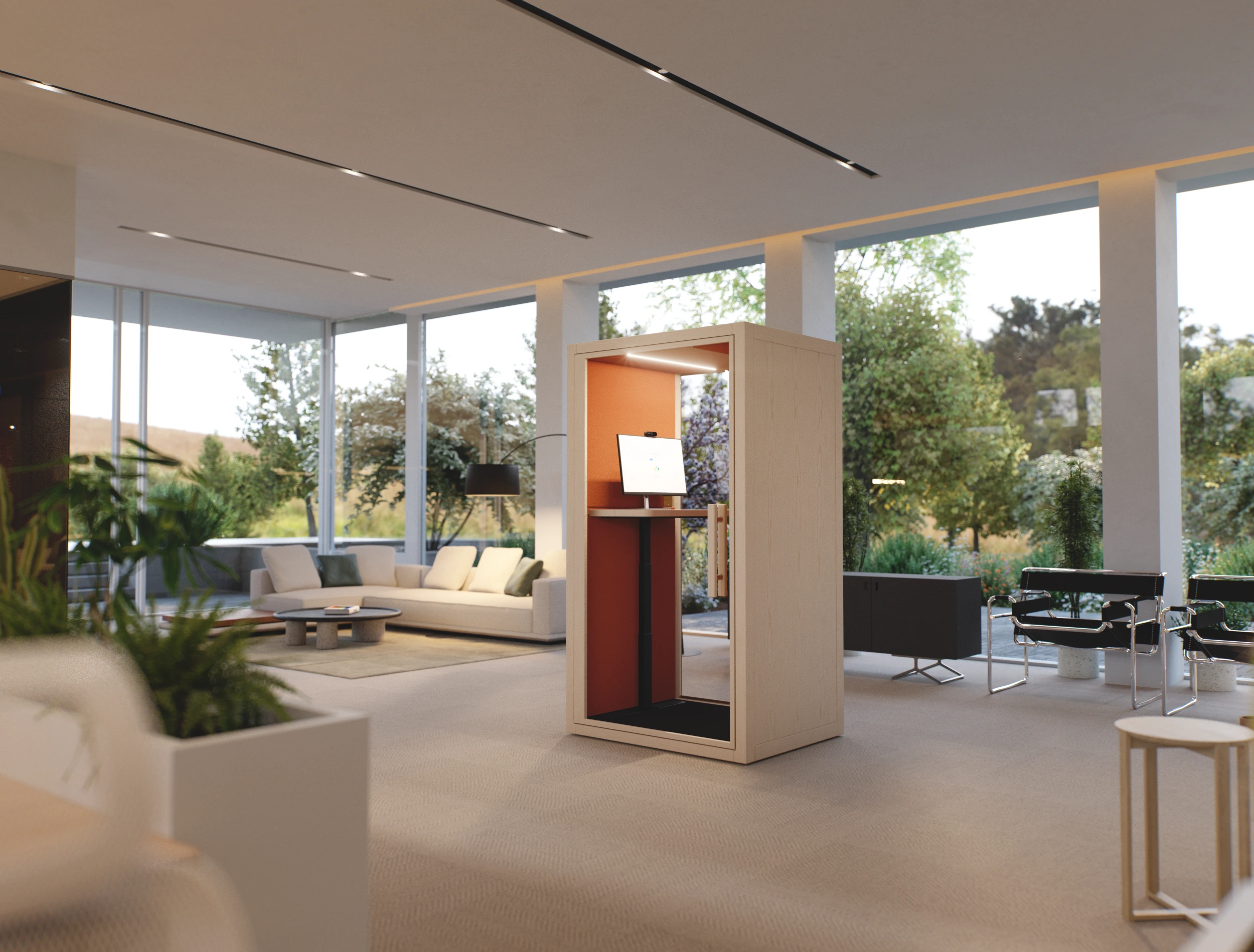 Modern soundproof work booth with built-in monitor and adjustable standing desk in a bright, open office space with natural lighting.